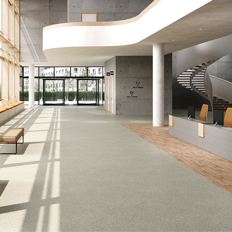 Hall d’accueil moderne avec revêtement de sol gris et décor bois
