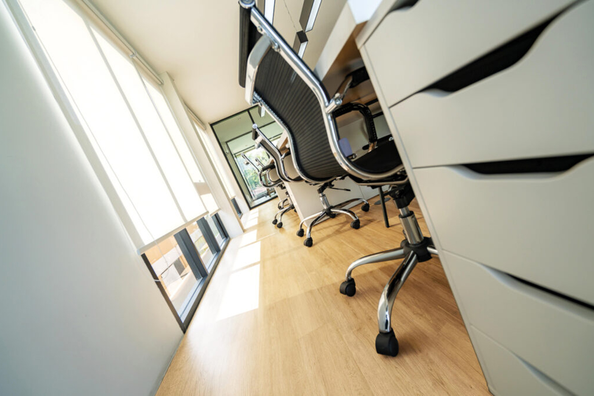 Bureau équipé de sièges à roulettes sur un sol imitation bois